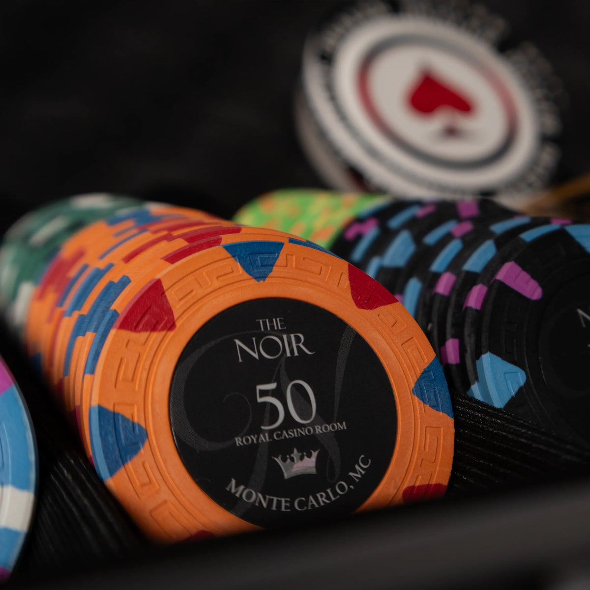 Stacks of clay poker chips with printed poker chip values on a poker table