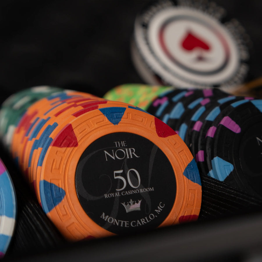 Stacks of clay poker chips with printed poker chip values on a poker table