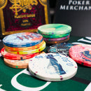 Colorful poker chips on a green felt surface with a card deck in the background.