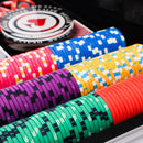 Colorful poker chips on a black surface with a close-up view.