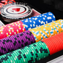 Colorful poker chips on a black surface with a close-up view.