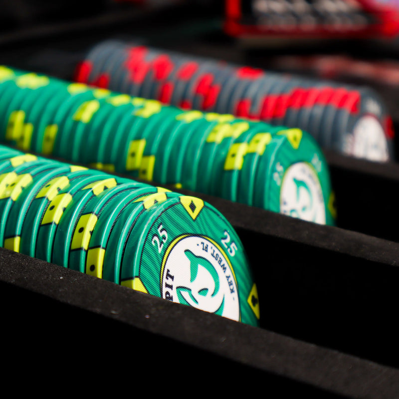 Close-up of green poker chips with yellow accents on a black rack.